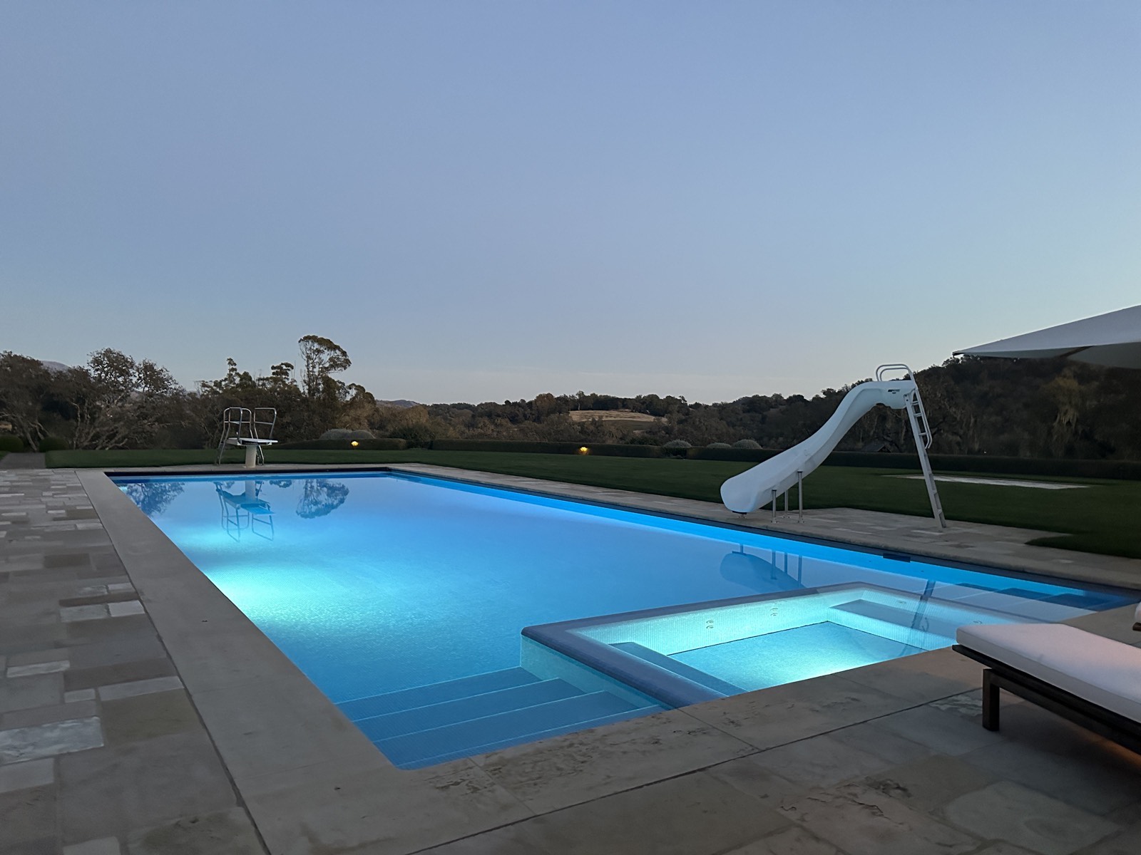 Pool at twilight with slide and hills
